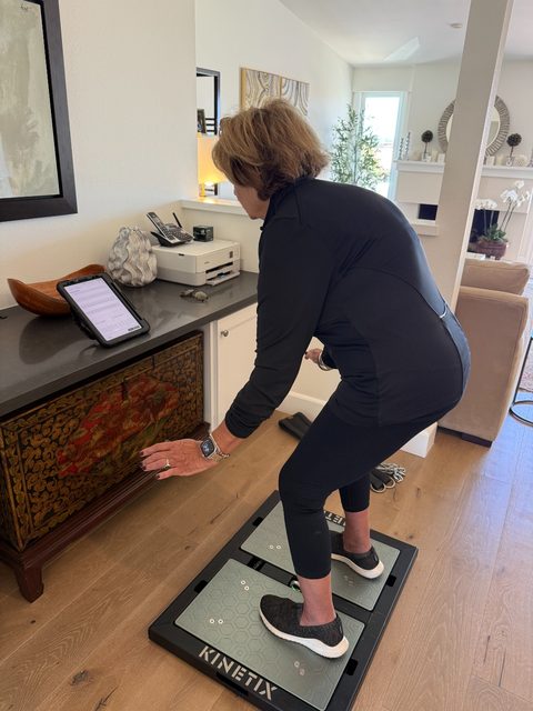 Client performing a step-down assessment on a VALD force plate during a fall-risk evaluation