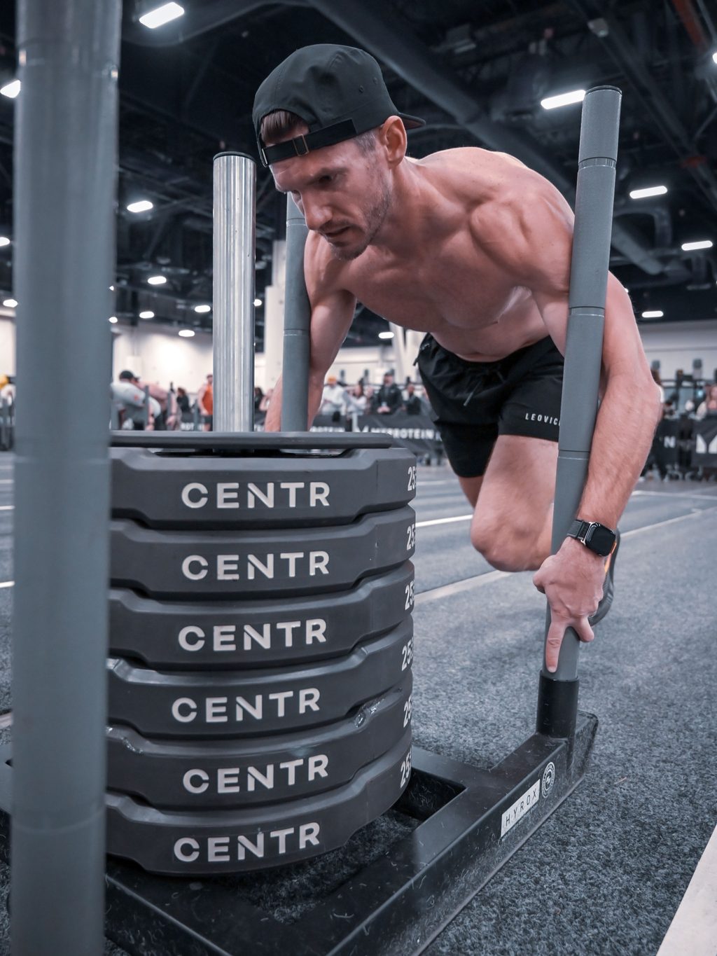 Dr. David Waltman pushing a weighted sled during a HYROX race